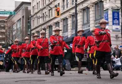 RCMP officers, dressed in ceremonial red serge, march through Vancouver for Remembrance Day Vancouver, BC, Canada – November 11, 2016: RCMP officers, dressed in ceremonial red serge, march through downtown Vancouver for Remembrance Day.