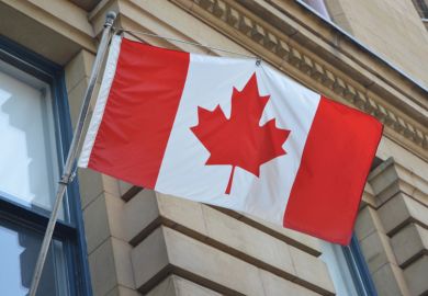 Canadian flag suspended outside building