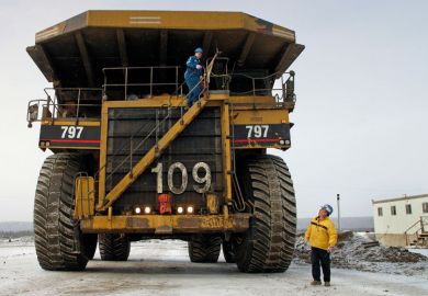 Canadian workmen operating large construction vehicle