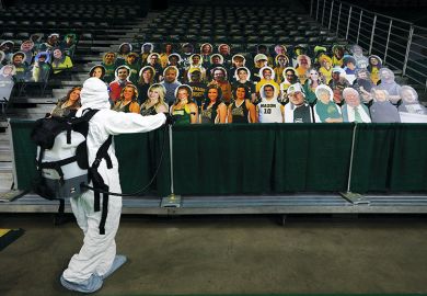 Man in PPE with audience of cardboard cut-out people, virtual conference, digital, remote