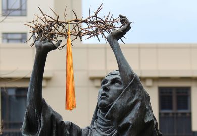Catholic statue of Catherine of Sienna holding a crown of thorns, St. Patrick's Cathedral, East Melbourne, Australia. With a mortarboard tassel added to illustrate the double act of being Catholic and being a university.