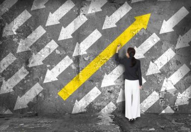 Someone colours a large arrow in yellow on a wall - it's pointing in the opposite direction to a number of smaller white arrow Change direction