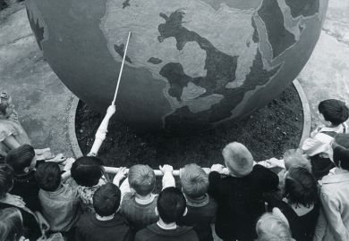 Children viewing globe during geography lesson