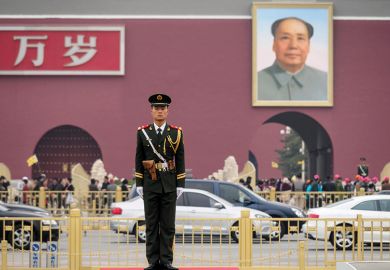 Chinese soldier with poster of Chairman Mao