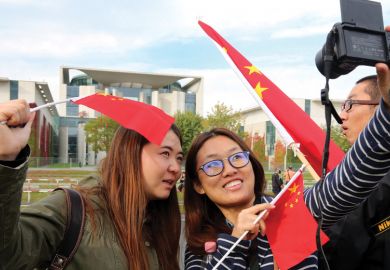 Two women take a selfie with Chinese flags Two women take a selfie with Chinese flags
