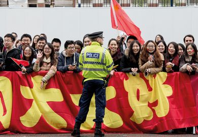 Chinese students show support for Chinese President Xi Jinping as he arrives to tour the National Graphene Institute at Manchester University in 2015