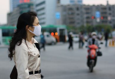 Chinese woman wearing a white face mask