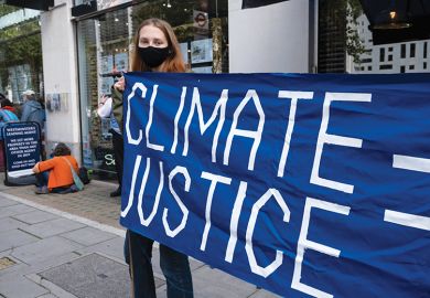 Woman holding climate justice protest banner
