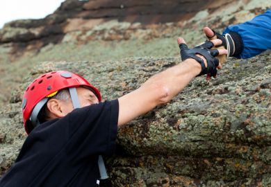 Climber being helped to climb mountain
