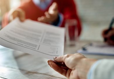 Close-up of job applicant giving his resume during job interview in the office.