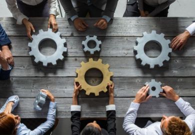 People hold unconnected cogwheels, one of which is gold