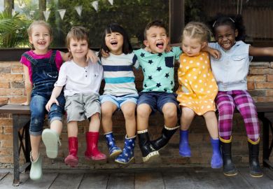 Children in wellington boots, arm in arm, representing collegiality Children in wellington boots, arm in arm, representing collegiality in higher education