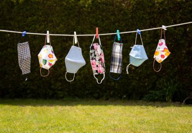 Colourful coronavirus masks in the garden hung up on a washing line