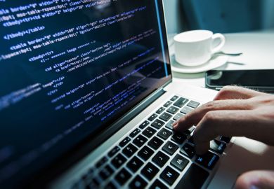 Computer programmer coding on laptop