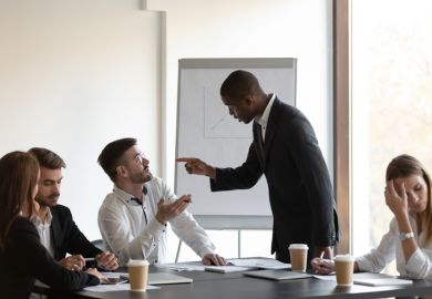 People gesticulate at each other in a business meeting People gesticulate at each other in a business meeting, symbolising conflict within business schools