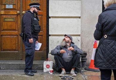 A police officer speaking with a man illegally busking on the recorder, Brick Lane, London