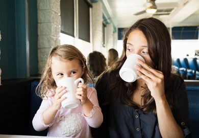 Woman and little girl drinking coffee