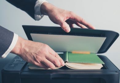 Man photocopying a book Man photocopying a book
