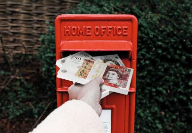 A hand stuffs banknotes into a post box marked ‘Home Office’ A hand stuffs banknotes into a post box marked ‘Home Office’