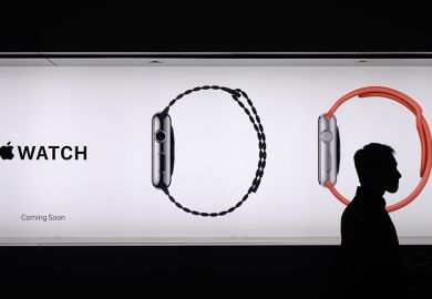 A man walks past a billboard ad for Apple watches, his head encircled by one of the images