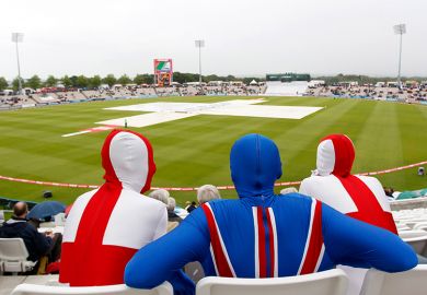Spectators in England and Union Jack costumes wait as rain delays play a cricket match between England and Sri Lanka. To illustrate extending the path to UK citizenship to more than 10 years could deter international researchers from settling in the UK.