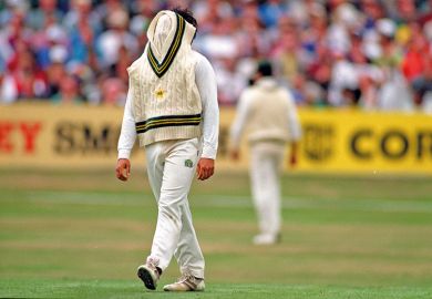 Cricketer with jumper over face