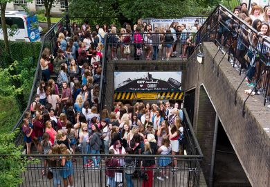 Crowd of fans queueing for a gig on stairs at Cardiff University, illustrating the university's plans to increase the staff-student ratio.