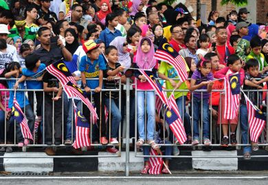 Crowd of people waving Malaysian flags Crowd of people waving Malaysian flags