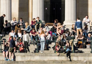 Crowd of University College London (UCL) students relaxing in sunshine