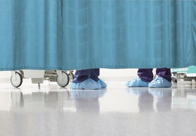 Feet of medical staff behind curtain
