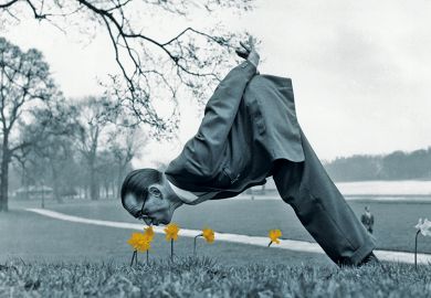 Man dressed in vintage suit sniffing daffodils