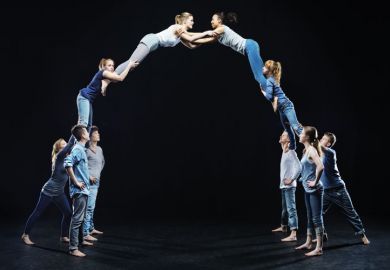 Dancers on stage forming human bridge