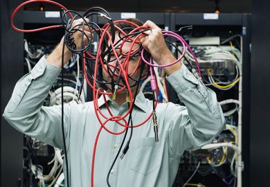 Man with tangled computer cables Man with tangled computer cables