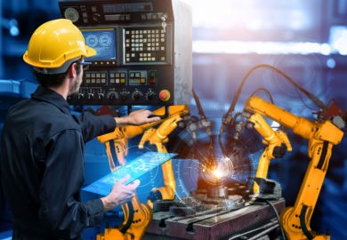 A man controls robot arms with an iPad, illustrating degree apprenticeships