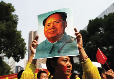 Demonstrator holding poster of Mao Zedong (Mao Tse-tung), Shanghai