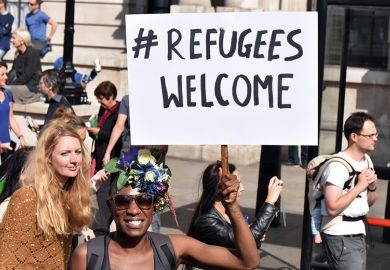 Demonstrator holding 'Refugees welcome' placard, London, England