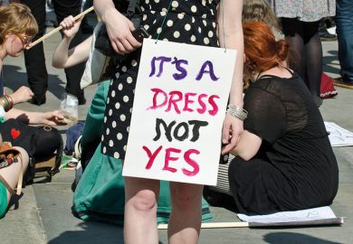 Demonstrator wearing 'It's a dress, not yes' placard