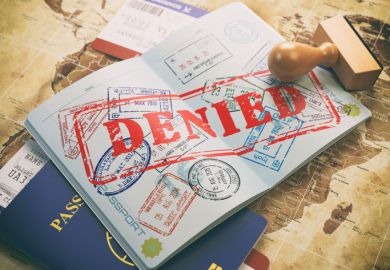 Passport with denied visa stamp on a map of the world 