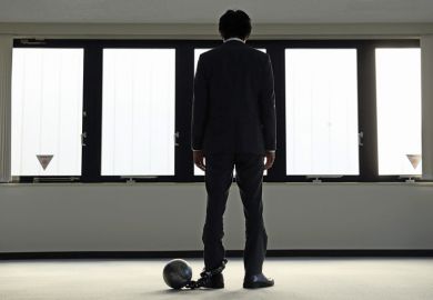 Depressed businessman with ball and chain around ankle Depressed businessman with ball and chain around ankle