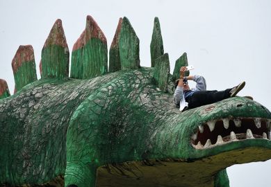 Man on dinosaur sculpture