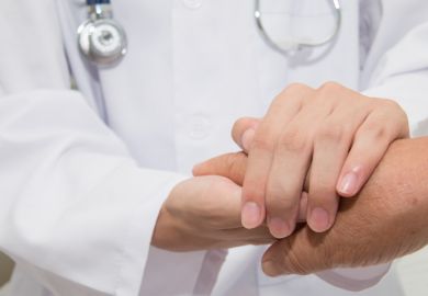 Doctor holding hands with patient