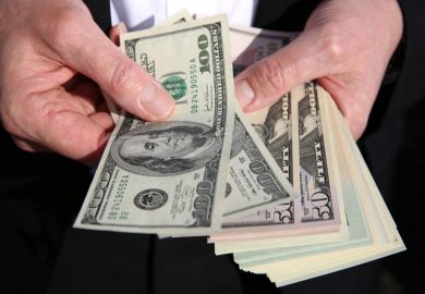 A person holding US dollars A person holding US dollars