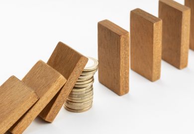 A pile of coins stops a row of dominoes from falling, symbolising capital investment