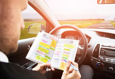 A man looking through his diary in a driverless car A man looking through his diary in a driverless car