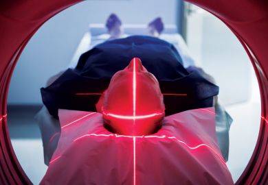 Elderly man lying down in Body CT (CAT Scan) machine