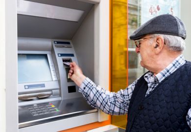 Elderly man inserting credit card to ATM