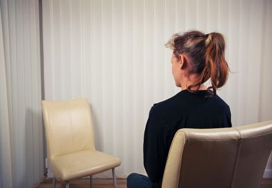 Seated woman looking at empty chair