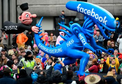 A carnival float depicting a judge holding the tail of an alien whereupon is written 'radicalisation, hate, rush, Facebook' in Germany 2020. To illustrate whether scholars on Facebook's oversight board are helping rule on moderation rows.