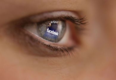 Reflection of Facebook logo on person's eye