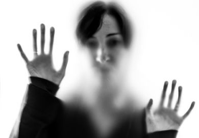 Shadowy woman figure behind frosted glass